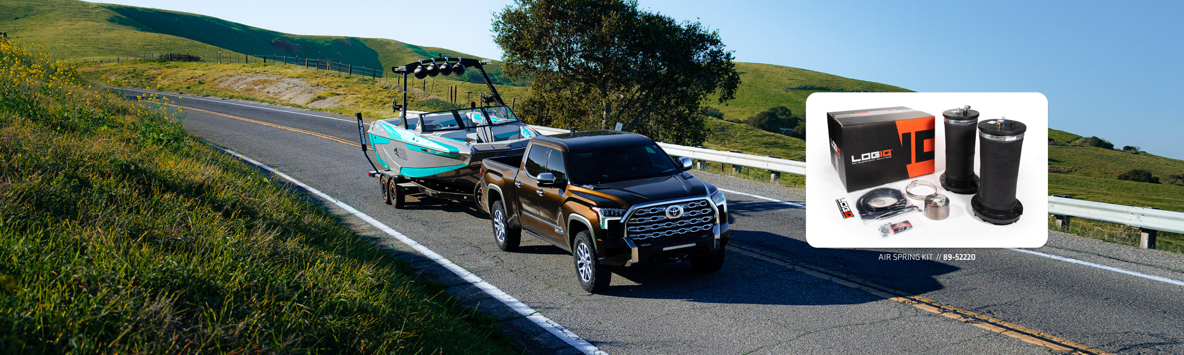 Toyota Tundra towing a boat on a country road with a LOGIQ air spring kit